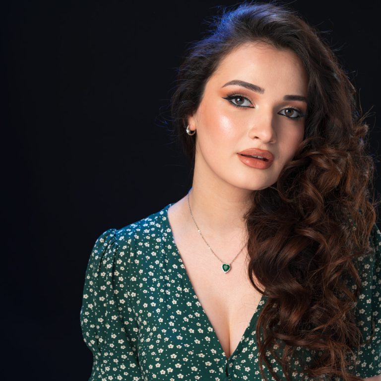 Studio portrait of a young beautiful brunette woman against black background, close up